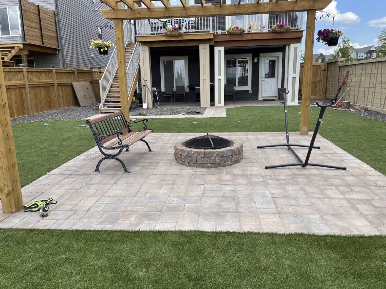 Backyard firepit on stone patio with pergola 768x576