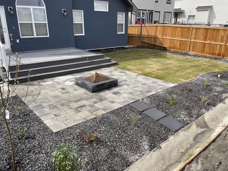 Backyard firepit with stone patio and composite decking 768x576