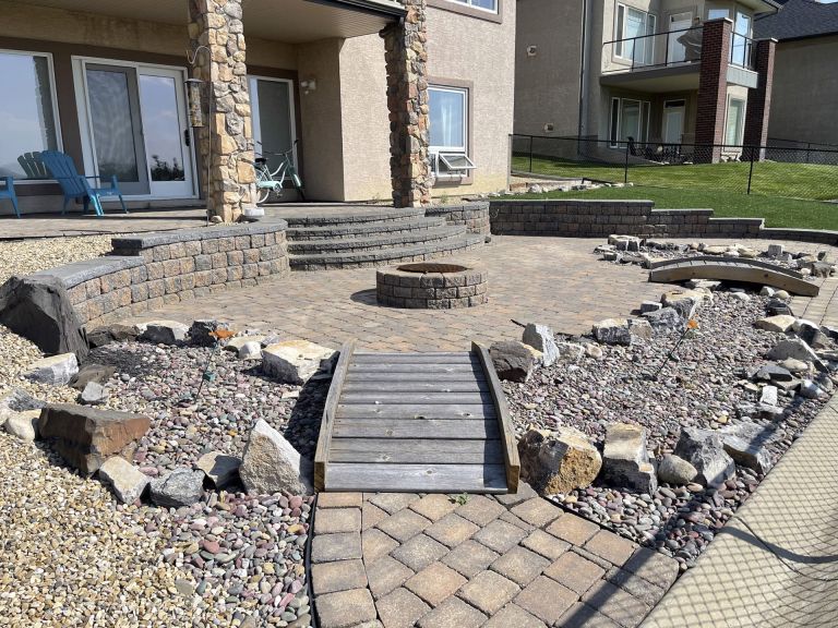 Lanscaped backyard with retaining wall and firepit 768x576