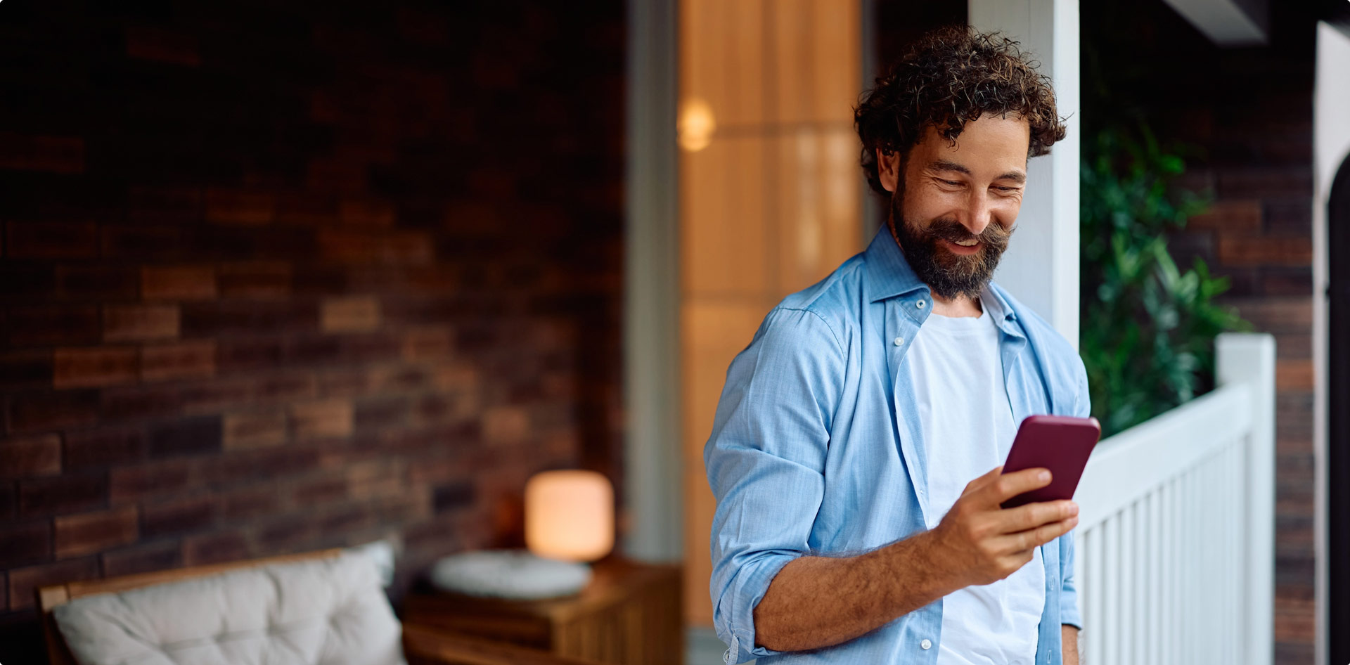Man smiling while looking at phone