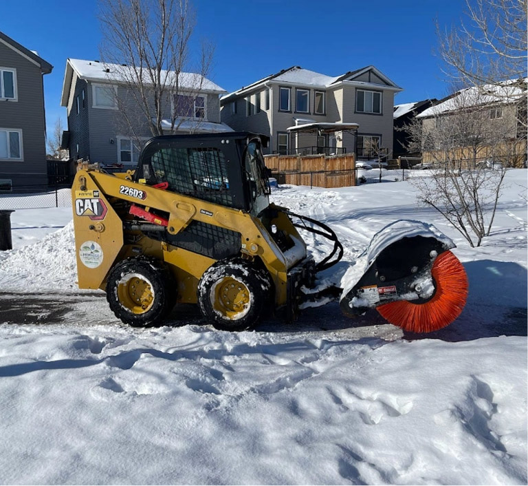 Snow removal using bobcat machine with brush